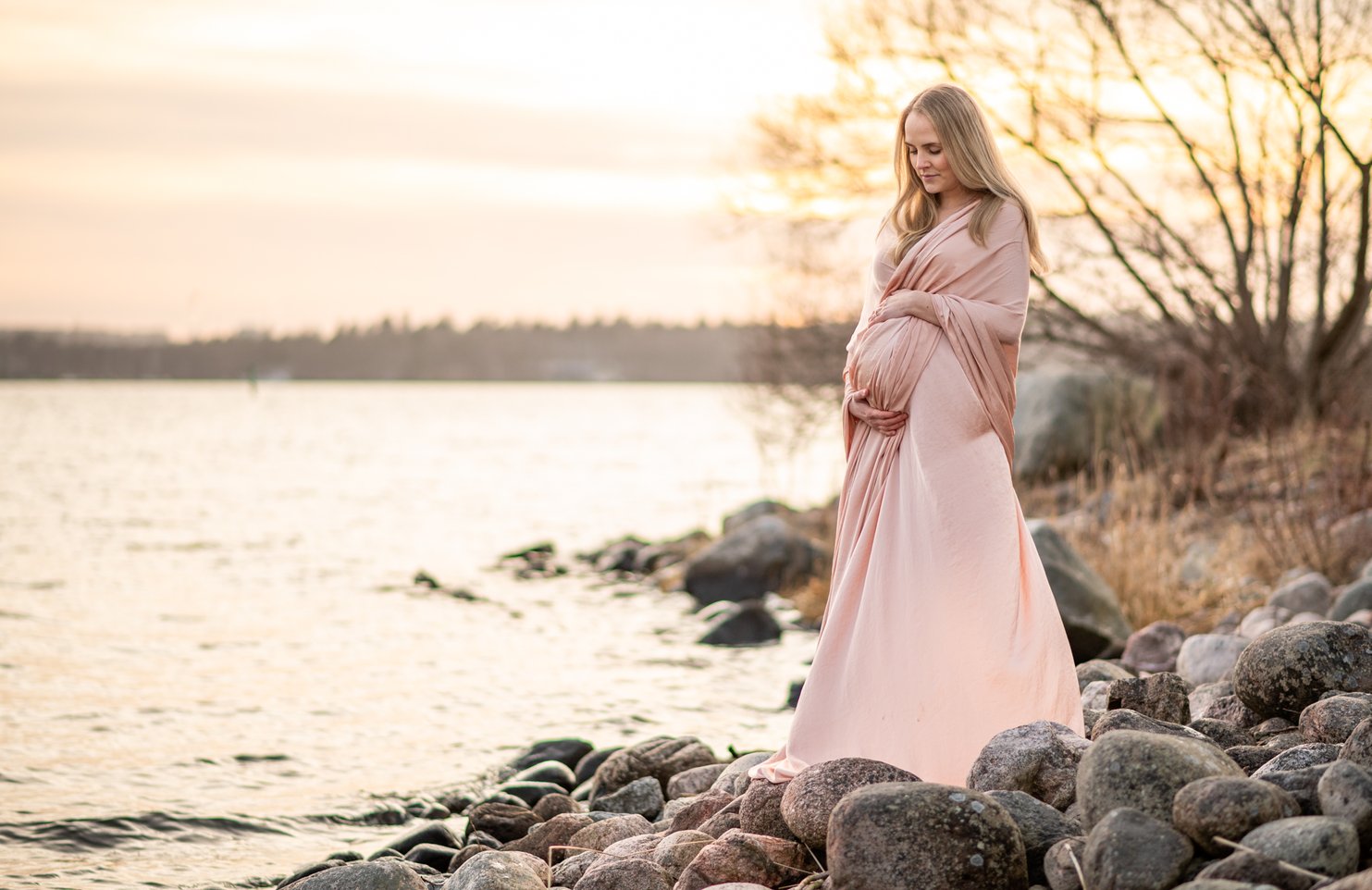 Gravidfotografering utanför stockholm på lidingö vid havet insvept i vacker sjal.